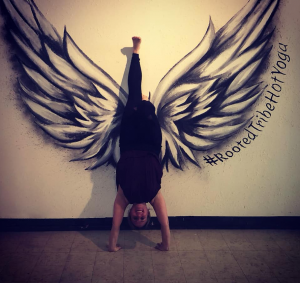 handstand in front of wings mural