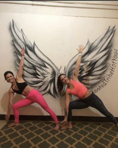 Hatha Triangle Pose In Front of Wings Mural