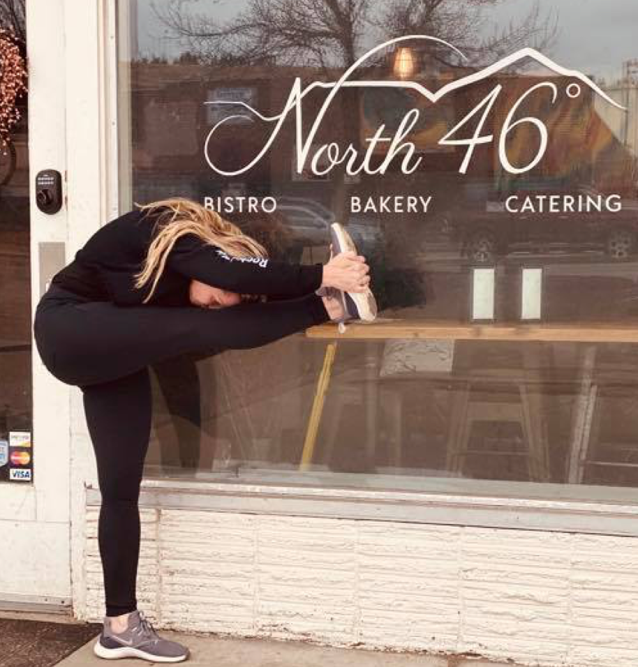 standing forehead to knee in front of local business